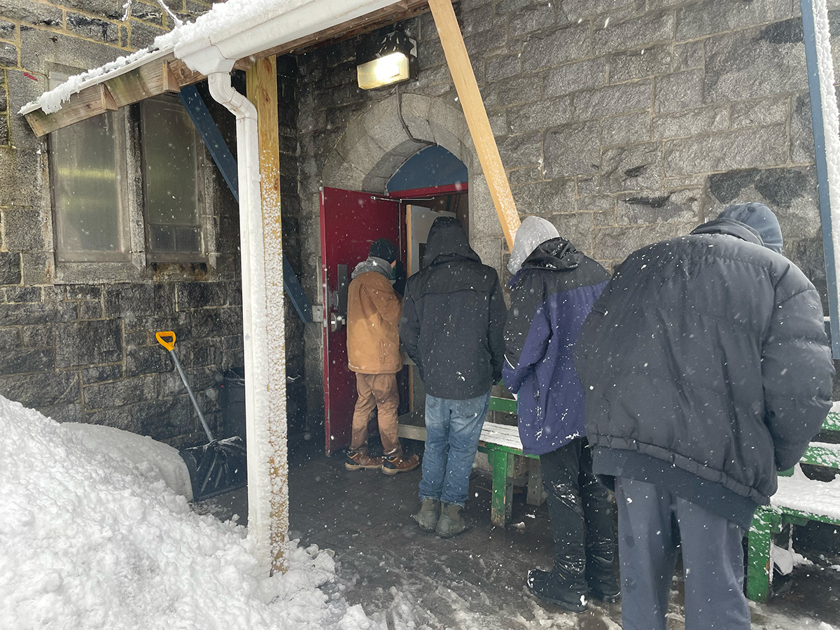 Soup Kitchen, winter, space challenges. Soup Kitchen guests line up outdoors during a snowstorm for food_